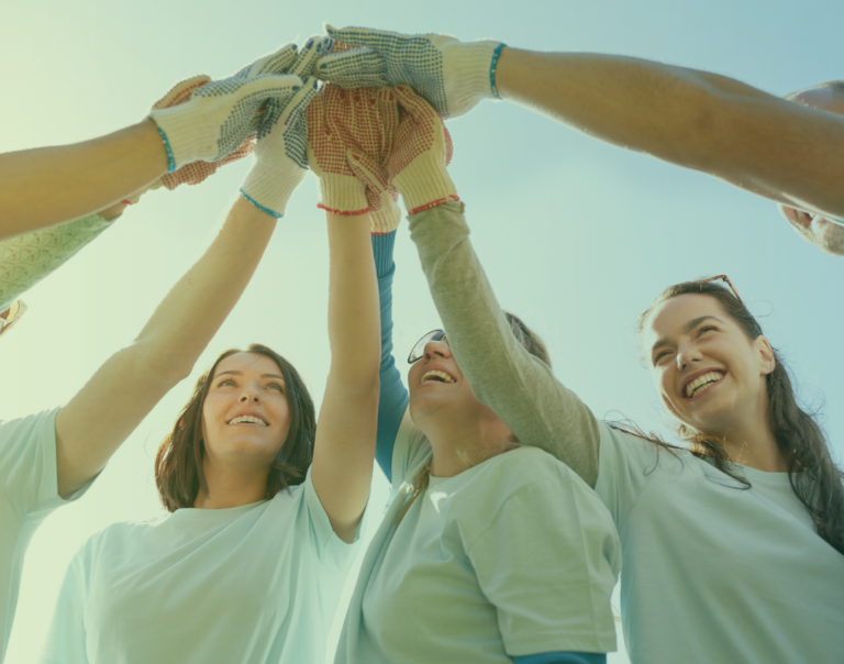 Volunteers joining hands as a symbol of flexible volunteering and collective impact
